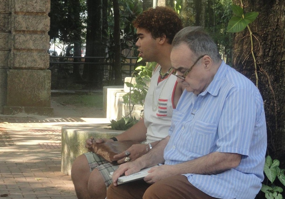 Marcos de Castro lendo para aluno do IBC na Praça dos Ledores