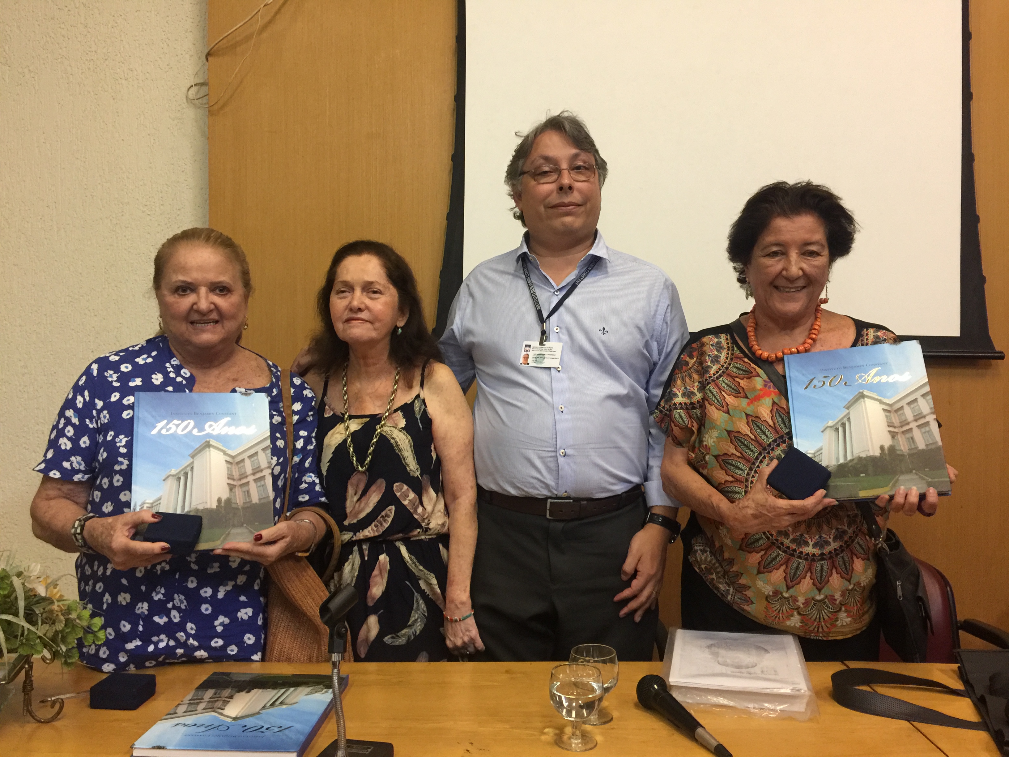 O diretor-geral do IBC, João Ricardo Melo Figueiredo, e a assessora do Gabinete Maria da Glória Almeida presentearam as descendentes de Xavier e Adélia Sigaud com o livro do 150 anos do IBC.
