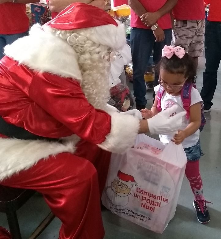 Aluna recebe brinquedo das mãos do Papai Noel